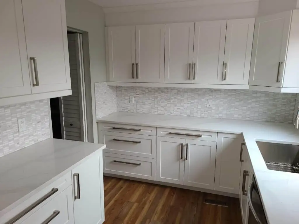 White shaker-style kitchen cabinetry and quartz countertops in a modern kitchen renovation.